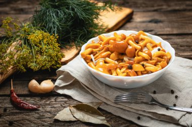 Koyu renkli ahşap bir masada turşular, hafif tekstil ve tahta kesim.