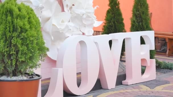 Love word outdoors. Big white plastic letters wedding decoration — Stock Video