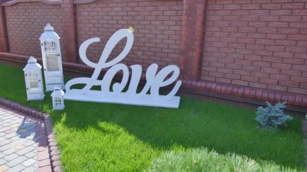 Palavra de amor ao ar livre. Grandes letras de plástico branco decoração do casamento — Vídeo de Stock