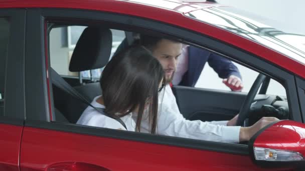 Casal jovem que assina um contrato no salão de exposições do carro — Vídeo de Stock