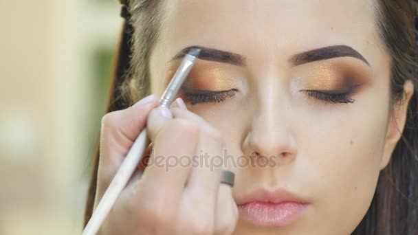 Lo stilista fa il trucco professionale degli occhi. Bellissimo modello . — Video Stock