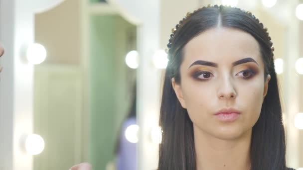 Kadeřnice dělá profesionální oční make-up. Krásný model. — Stock video