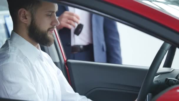 Autohandelaar geeft de klant de autosleutels in auto — Stockvideo