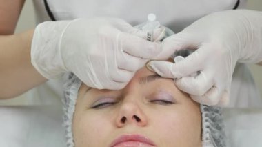 Genç güzel kadın karşısında klinik tedavinin bir parçası gibi kozmetik enjeksiyon alıyorum. Tıp, sağlık ve güzellik kavramı