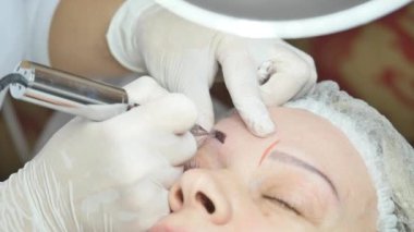 Kadının yüzünde kalıcı makyaj yapma güzellik uzmanı