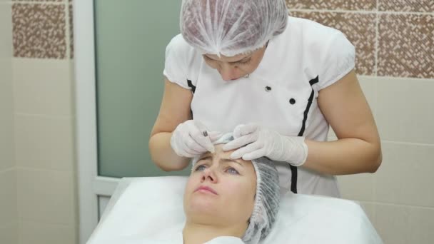 Médico dibuja líneas con marcador en la cara del paciente para cirugía plástica facial en la clínica — Vídeos de Stock