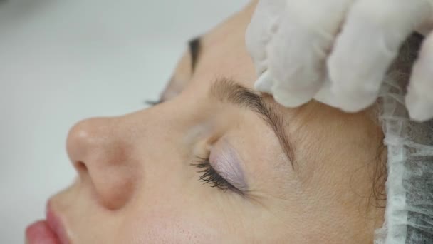 Молодая красивая женщина получает косметическую инъекцию в лицо, как часть лечения в клинике. Медицина, здравоохранение и красота — стоковое видео