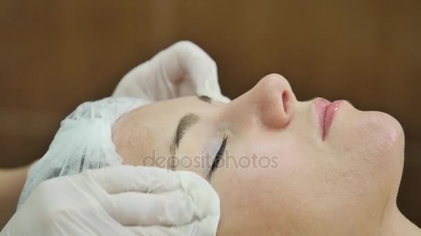 Kosmetikerin trägt Gesichtsmaske auf die Haut der Mädchen auf — Stockvideo
