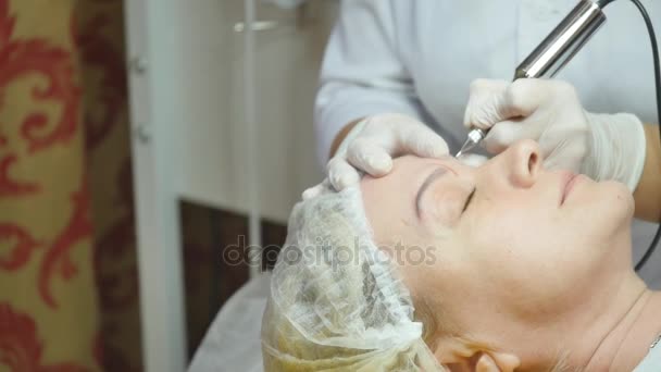 Cosmetologist making permanent makeup on womans face — Stock Video