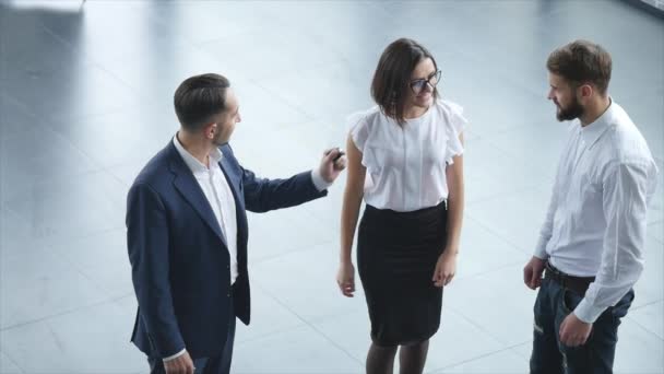 Vista superior de los jóvenes consultor masculino y los compradores que firman el contrato para el coche nuevo en el espectáculo de automóviles. Concepto de alquiler de coches — Vídeo de stock