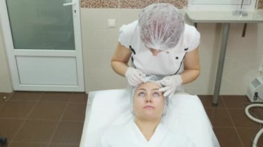 Doktor hasta yüz yüz plastik cerrahi kliniğinde için Tarih marker ile çizgiler çizmek