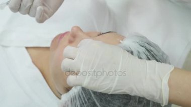 Güzel genç kadın botox enjeksiyon onun yanak içinde oluyor.