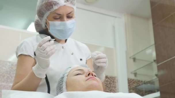 Güzel genç kadın botox enjeksiyon onun yanak içinde oluyor. — Stok video