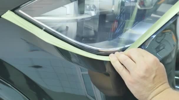Karosseriemaler maskiert Autoteile mit Klebeband und Papier — Stockvideo