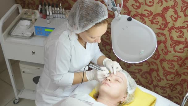 Cosmetologist making permanent makeup — Stock Video