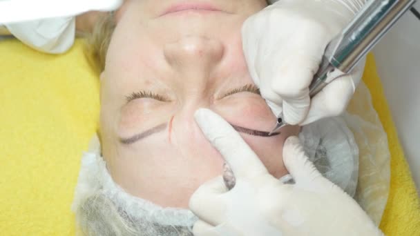 Cosmetoloog die permanente make-up maakt — Stockvideo