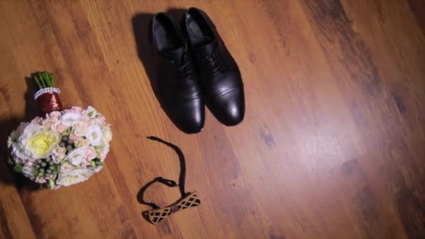 Conjunto de gravata do noivo arco, boutonniere, e sapatos jazem no fundo de madeira — Vídeo de Stock