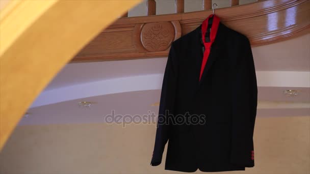 Chaqueta y corbata roja colgando de una puerta — Vídeo de stock