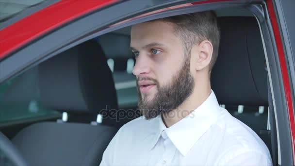 Mladý muž sedí v autě drží klíče od auta — Stock video