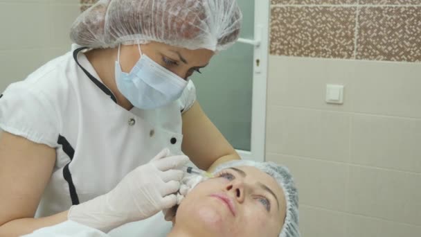 Woman middle-aged in spa salon with beautician. Botox injections. — Stock Video