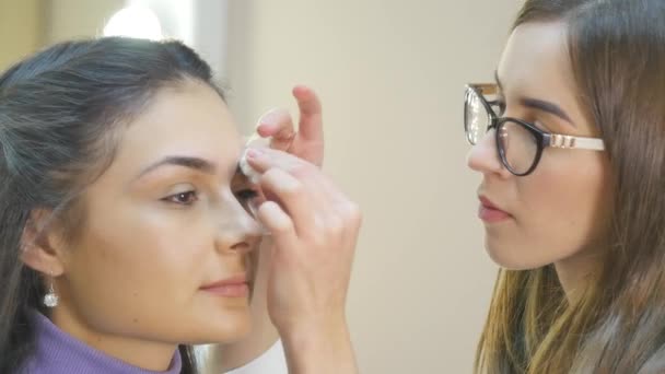 Make-up artist tillämpa pulver med en borste på modeller kinder — Stockvideo