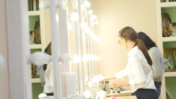 Make-up artist applying powder with a brush on models cheeks — Stock Video