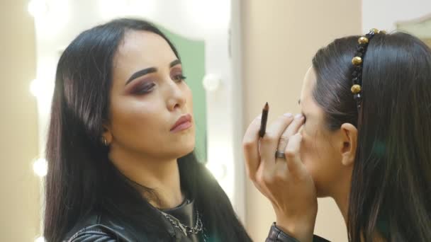 Estilista hace maquillaje de ojos profesional. Hermosa modelo . — Vídeo de stock