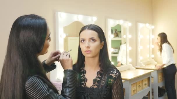 Estilista hace maquillaje de ojos profesional. Hermosa modelo . — Vídeos de Stock