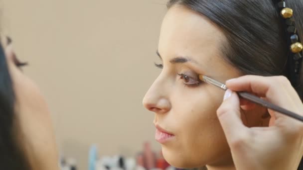 Estilista hace maquillaje de ojos profesional. Hermosa modelo . — Vídeos de Stock