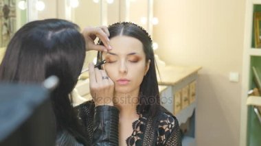 Makyaj. Kadın portre makyaj uygulamak. Göz kalemi. Kozmetik kaptırdın. Makyaj için eyeline fırça. Mükemmel cilt güzellik kız. Kirpik. Kahverengi gözler. Baştan Yaratma