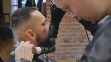 Ciddi genç adam saçlarını Kuaför tarafından Getting sakallı. Berber Tema. Ağır çekim.
