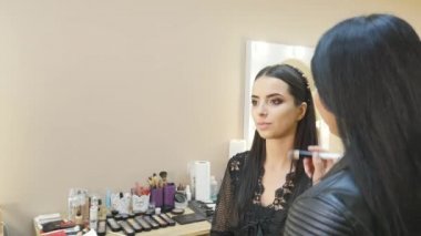 Genç kadın modeli salonda makyaj uygulamak