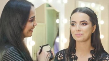 Genç kadın modeli salonda makyaj uygulamak