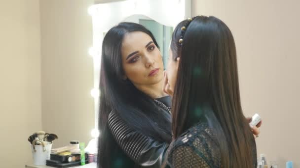 Joven hermosa mujer asiática aplicando maquillaje por maquillaje artista — Vídeos de Stock