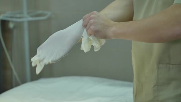 Chirurg zieht Handschuhe an — Stockvideo