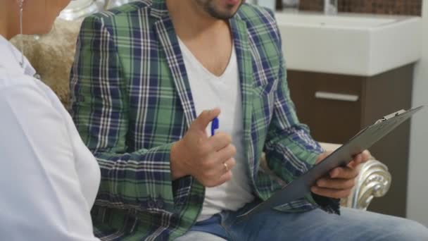 Dokter in gesprek met haar mannelijke patiënt op kantoor — Stockvideo