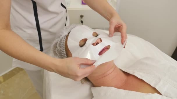 Esteticista aplica máscara facial para a pele das meninas — Vídeo de Stock
