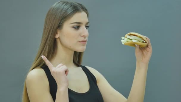 Концепция быстрого питания. Вкусный нездоровый бутерброд с гамбургером в руках голодный рот готовится к еде — стоковое видео