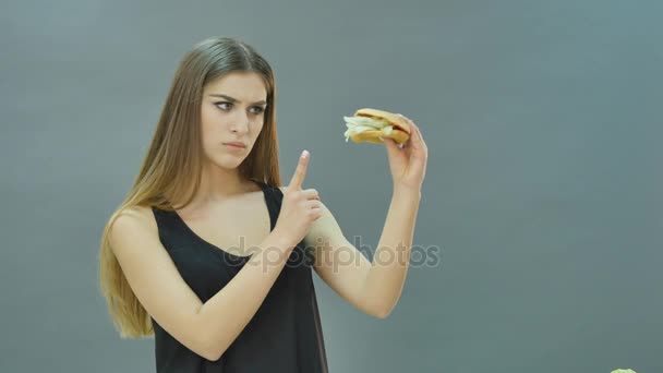 Σκληρή επιλογή: μήλο ή μπιφτέκι, flustered κοπέλα αποφάσισε να πάει σε μια διατροφή — Αρχείο Βίντεο