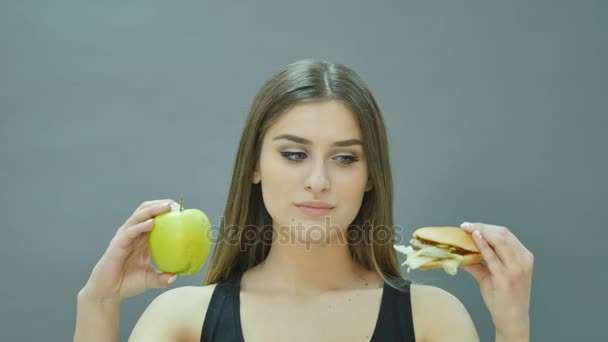 Difícil elección: manzana o hamburguesa, chica nerviosa decidió seguir una dieta — Vídeos de Stock