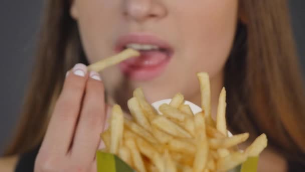 Fiatal nő eszik a francia krumpli közeli részlet — Stock videók