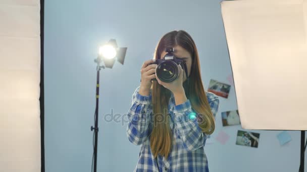 Молодая женщина-фотограф с камерой в профессионально оборудованной студии — стоковое видео