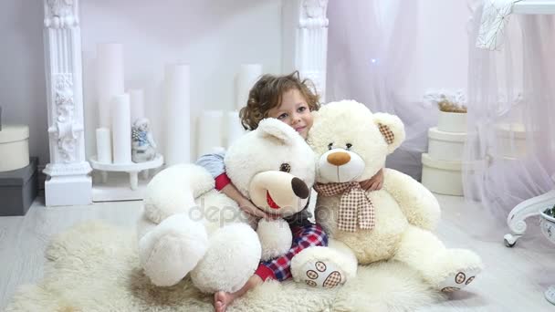 Το χαριτωμένο μικρό κορίτσι παίζει με αρκουδάκι κρεβάτι σε δωμάτιο διακοσμημένο για το νέο έτος. Τα Σαββατοκύριακα του χειμώνα. Ζεστή ατμόσφαιρα. Ατμόσφαιρα διακοπών — Αρχείο Βίντεο