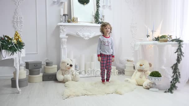 Κορίτσι με τις πυτζάμες πηδάω επάνω σε κρεβάτι. Η έννοια των Χριστουγέννων. Φωτογράφηση με φλας — Αρχείο Βίντεο