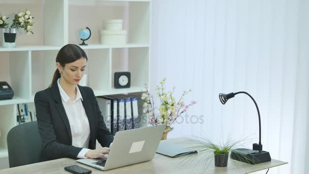 Joven mujer de negocios bonita con cuaderno en la oficina — Vídeos de Stock