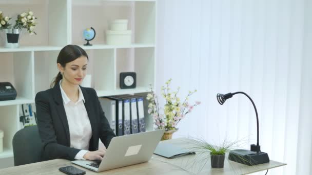 Jovem mulher de negócios bonita com notebook no escritório — Vídeo de Stock