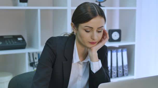 Pracownik biurowy nudzi przy biurku, wpatrując się w ekran komputera ręką na brodzie — Wideo stockowe