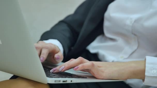 Joven mujer de negocios sentada en el sofá, trabajando con computadora portátil — Vídeos de Stock