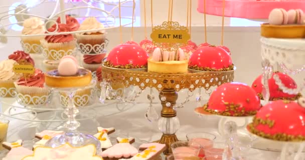 Délicieux buffet sucré avec cupcakes, meringues et autres desserts. Avec le texte "Mange-moi" — Video