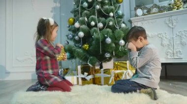 küçük kız ve erkek kardeşim hediye açmak. Noel ve yeni yıl kavramı